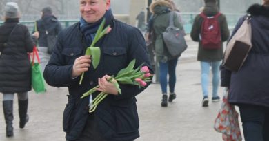 Bartłomiej Wróblewski na ulicy, w zimnie, rozdaje tulipany w Dzień Kobiet