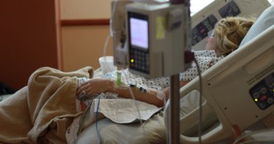 Kobieta w ciąży podczas pobytu w szpitalu, leżąca na łóżku i podłączona do kroplówek i aparatury