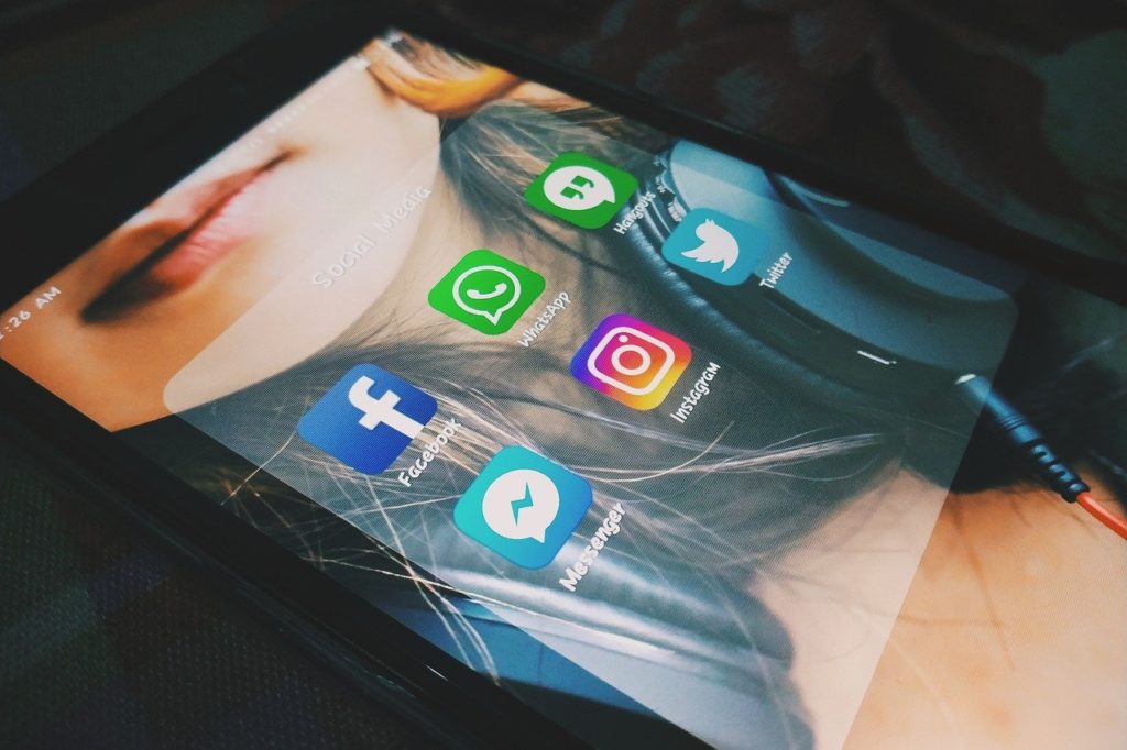 ekran smartfona ze zdjęciem dziewczyny i ikonami serwisów społecznościowych
